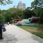art installation in a public park of a giant sleeping monkey made out of flip-flop slippers