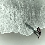 photograph of a swimmer walking to shore away from the surf