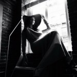 woman with hat sitting at window
