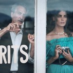 fashion shoot photo of woman with camera and main behind glass