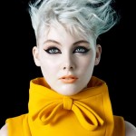 portrait of a woman with short blonde hair and a yellow dress