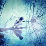 cross-processed photo of a woman in a swimsuit leaning near the edge of water