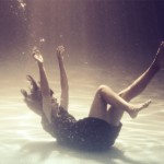 photograph of a woman sinking to the bottom of a swimming pool