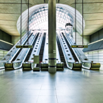 picture of a woman in a subway station near bank of escalators
