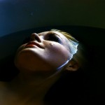 blonde woman smiling half submerged in water
