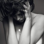 nude woman holding her head