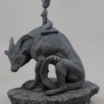 unpainted sculpture of woman sitting on gigantic horned hound-like creature