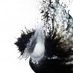 High-speed photograph of a frozen moment as water and black-ink splash into each other