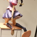 statue of girl kneeling on school desk holding celphone