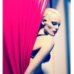 woman behind red curtain with spiky bra
