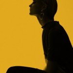 woman in profile against yellow background