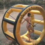 woman in pink tiger stripe swimsuit on water on inflatable wheel