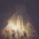 hands seen through illuminated lace dress
