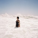 woman in black swimsuit looking at surf