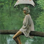 woman with umbrella sitting on log over water