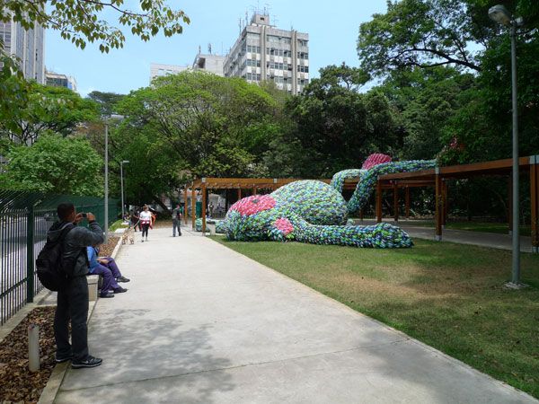art installation in a public park of a giant sleeping monkey made out of flip-flop slippers