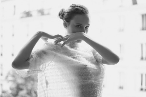 black & white photo of a woman wearing a sheer embroidered white sheet