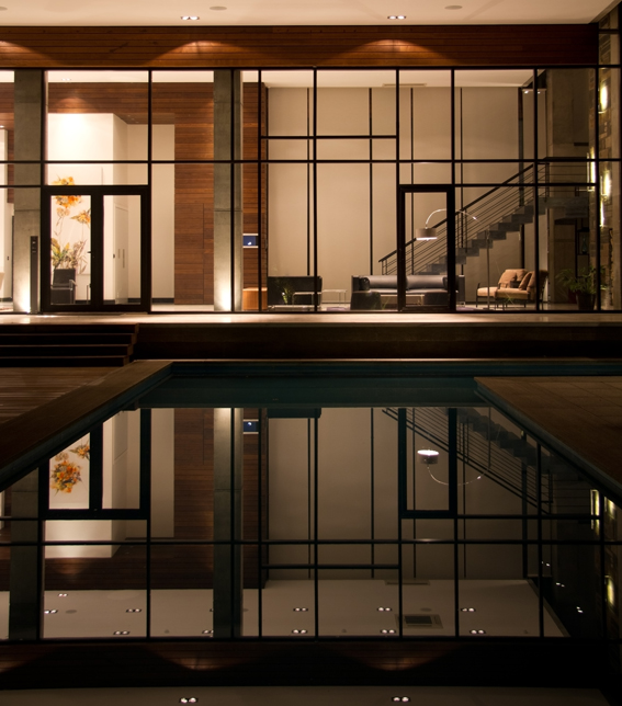 photo of a house at night and its swimming pool