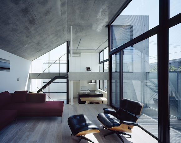 interior of house with bare concrete walls and eames chair