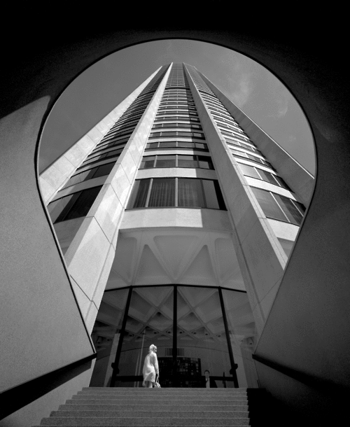 black & white picture of a skyscraper with a woman in front