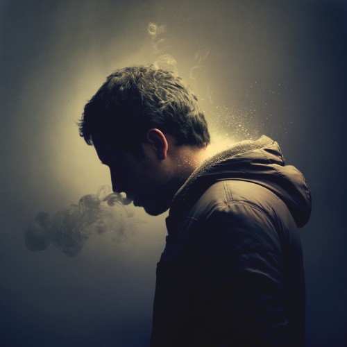 picture of a man in profile blowing smoke