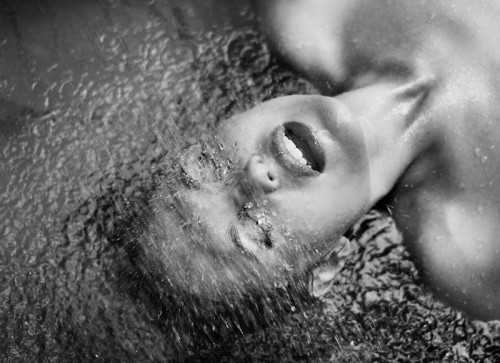 black & white photo of a woman under a shower