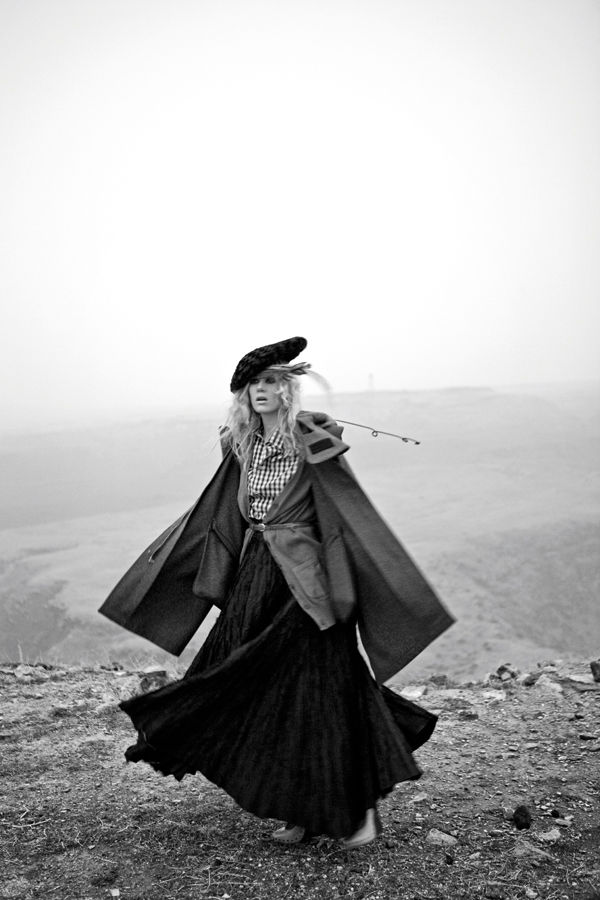 black and white photo of a woman walking on a foggy hillside