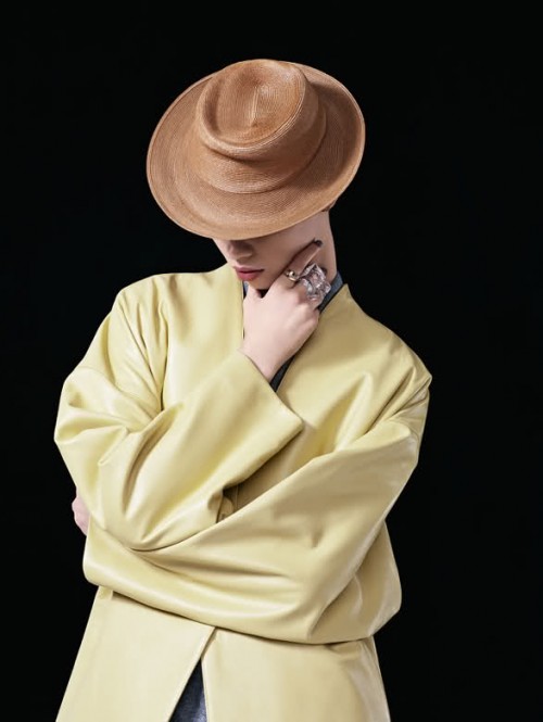 photograph of a woman in a hat wearing a light yellow top