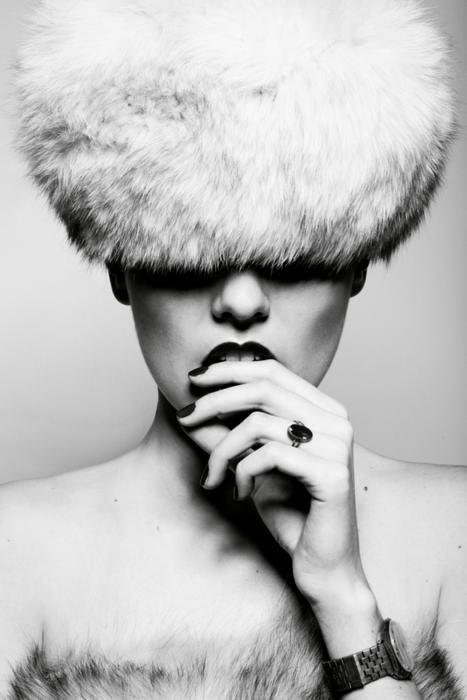 black & white picture of a woman in a fur hat biting her lip