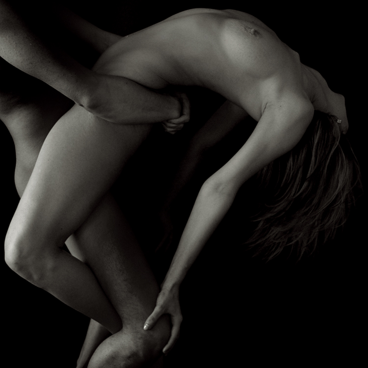 black & white photo of nude male carrying a nude female with back arched