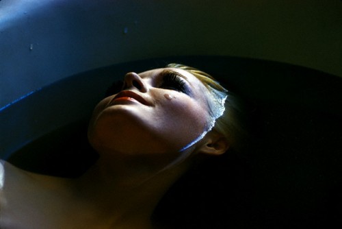 blonde woman smiling half submerged in water