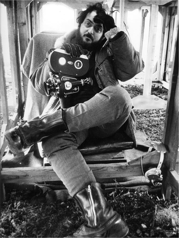 Stanley Kubrick looking bored holding a film camera