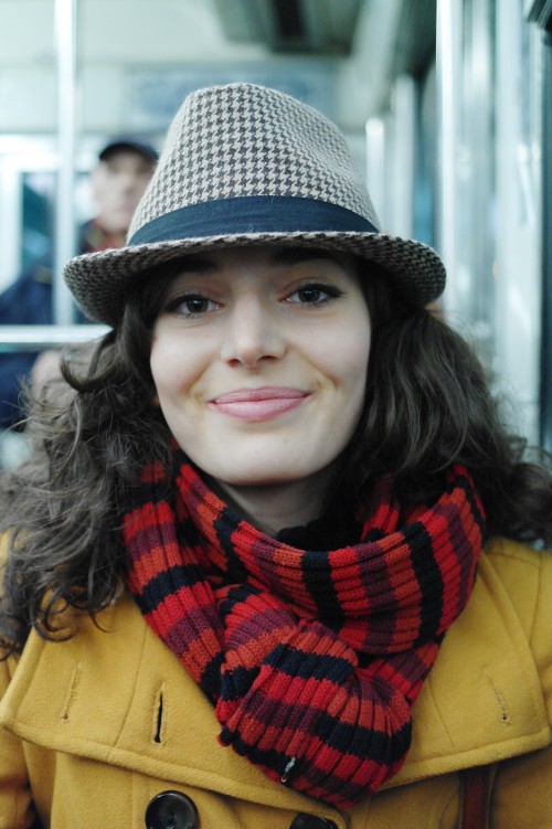 photo of a woman on paris metro wearing hat, scarf and coat