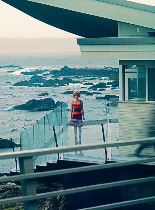 woman standing in balcony of beachside house
