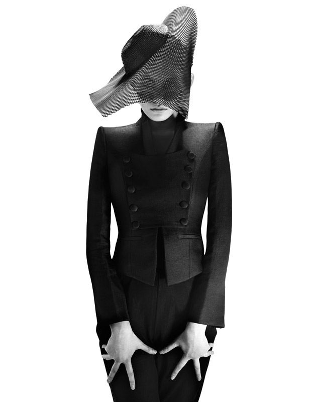 woman in black outfit with futuristic hat with incorporated veil