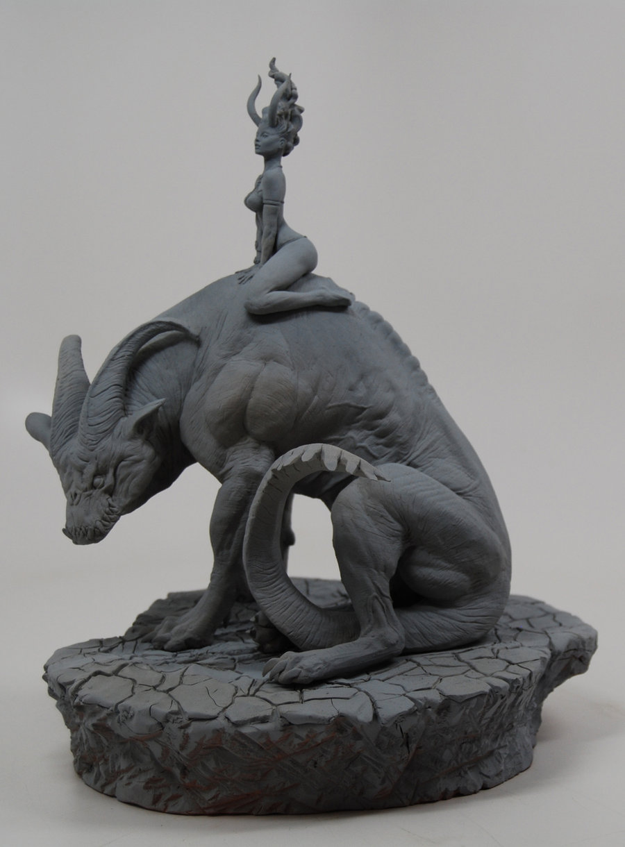 unpainted sculpture of woman sitting on gigantic horned hound-like creature