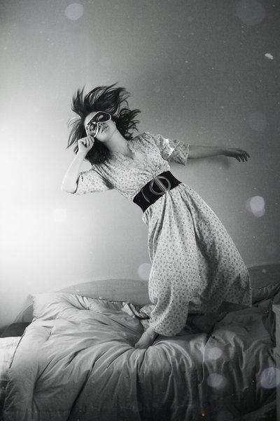 Masked woman falling on bed