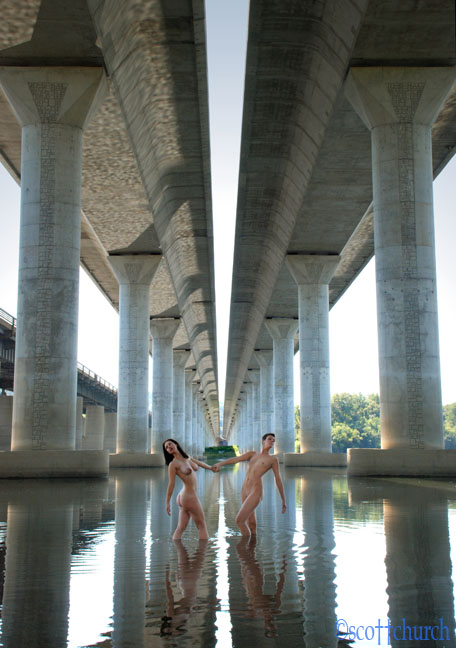 Pair of nude models under a bridge