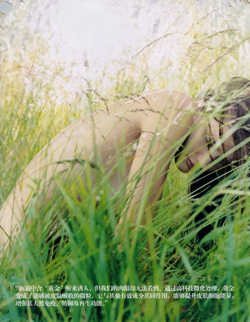 Rosie Huntington-Whiteley crouching nude in tall grass