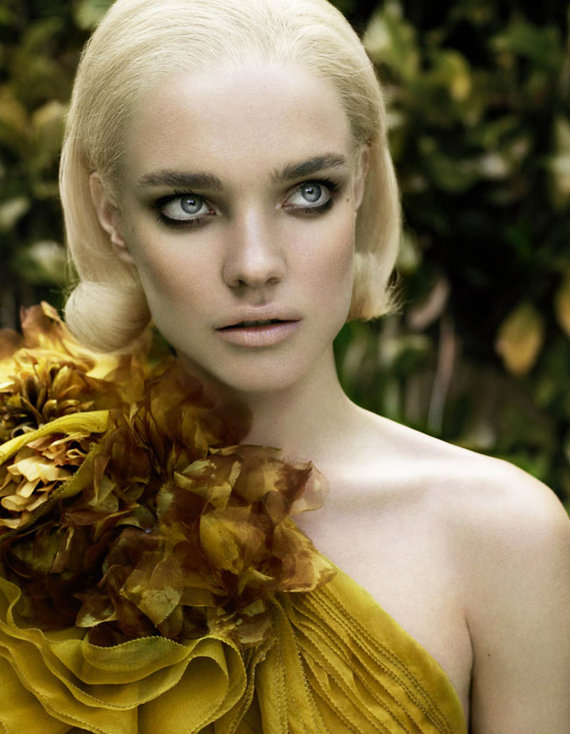 close up of natalia vodianova with blonde hair wearing gauzy gold off-shoulder dress