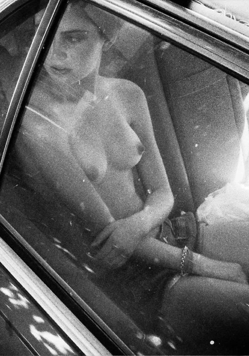 nude woman in car looking out window