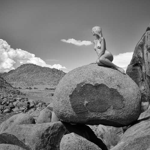 Emmy Grace sits on boulders in the nude