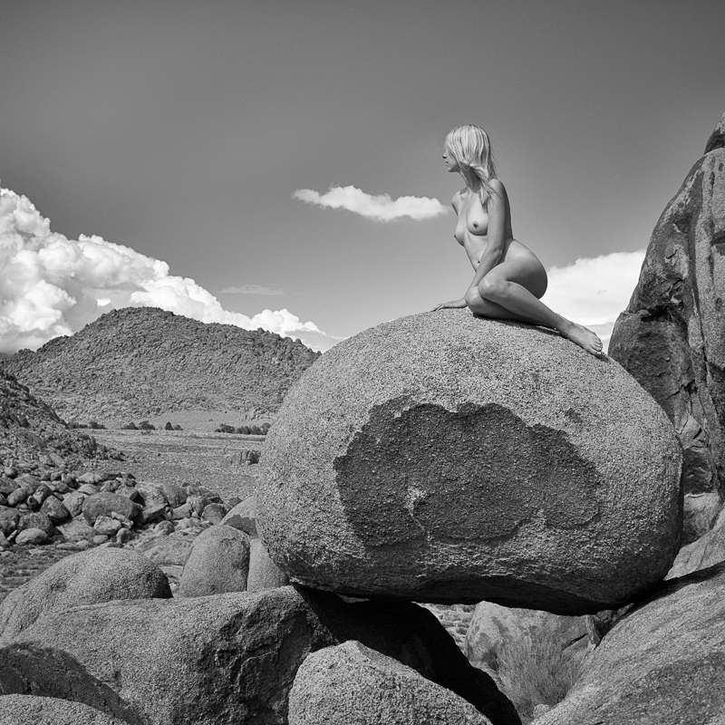 Emmy Grace sits on boulders in the nude